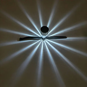Solar railing light casting a starburst light pattern on a wall
